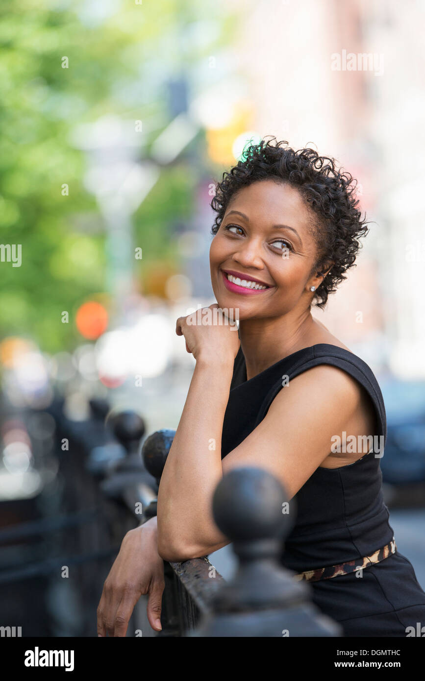 Les personnes en déplacement. Une femme en robe noire sur une rue de la ville. Banque D'Images