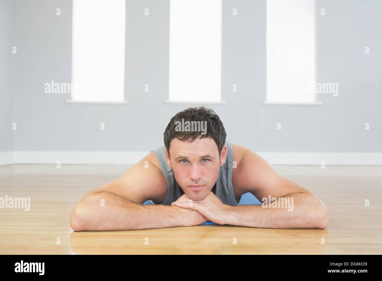 L'homme sportif du contenu se trouvant sur le plancher Banque D'Images