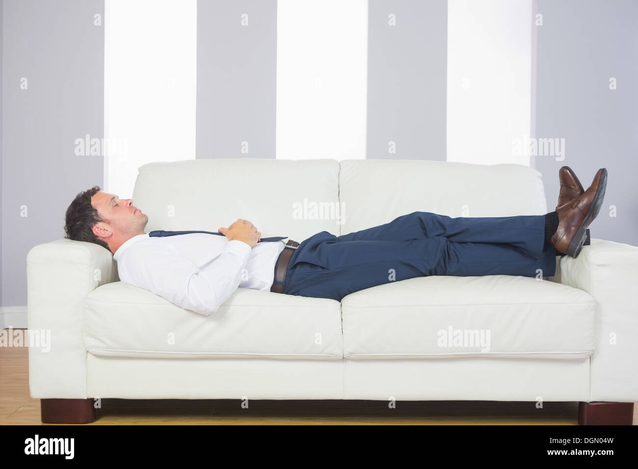 Calm handsome businessman lying on couch Banque D'Images