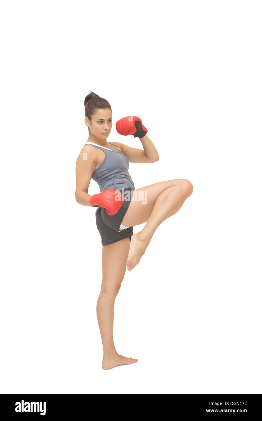 Concentrant sporty brunette kick boxing Banque D'Images