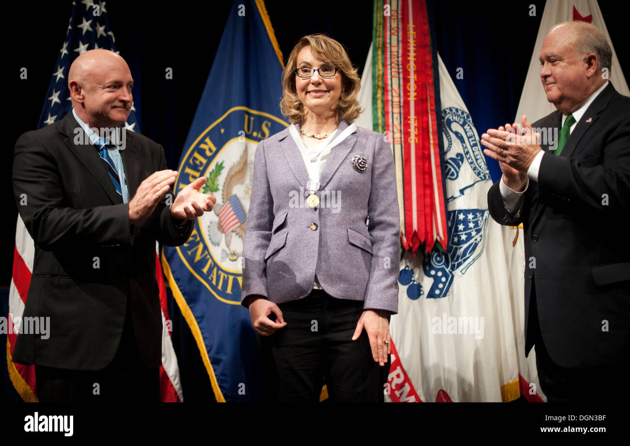 Ancien Rempl. Gabrielle Giffords 'Gabby' (Arizona) d'être applaudi par le sous secrétaire de l'Armée de Joseph W. Westphal (à droite) et son mari a pris sa retraite le Capitaine de vaisseau Mark Kelly (à gauche), juste après qu'elle a été présentée avec l'Armée de décoration pour distinguer C Banque D'Images