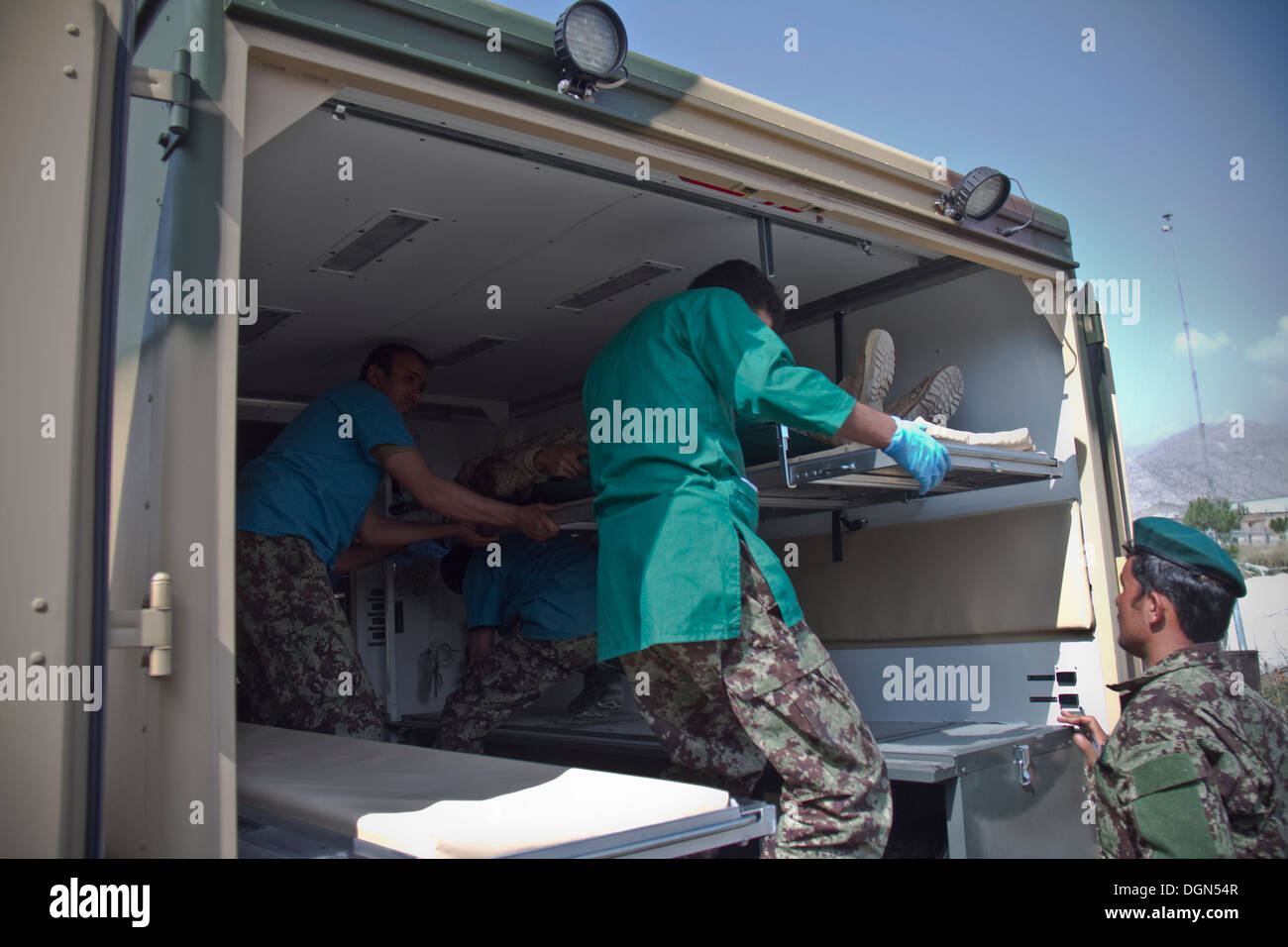 La province de KHOWST, Afghanistan - Medecins avec l'Armée nationale afghane en charge victimes simulées à l'arrière d'une ambulance, de la litière sur le terrain un grand nombre de victimes au cours de l'exercice sur Parsa, l'Afghanistan, le Camp du 12 octobre 2013. Banque D'Images