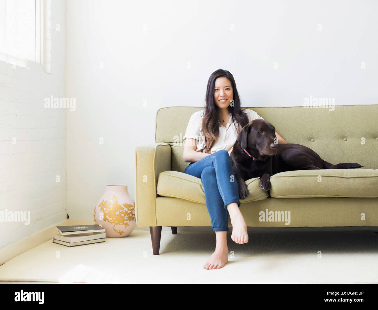Portrait de femme avec chien assis sur le canapé Banque D'Images