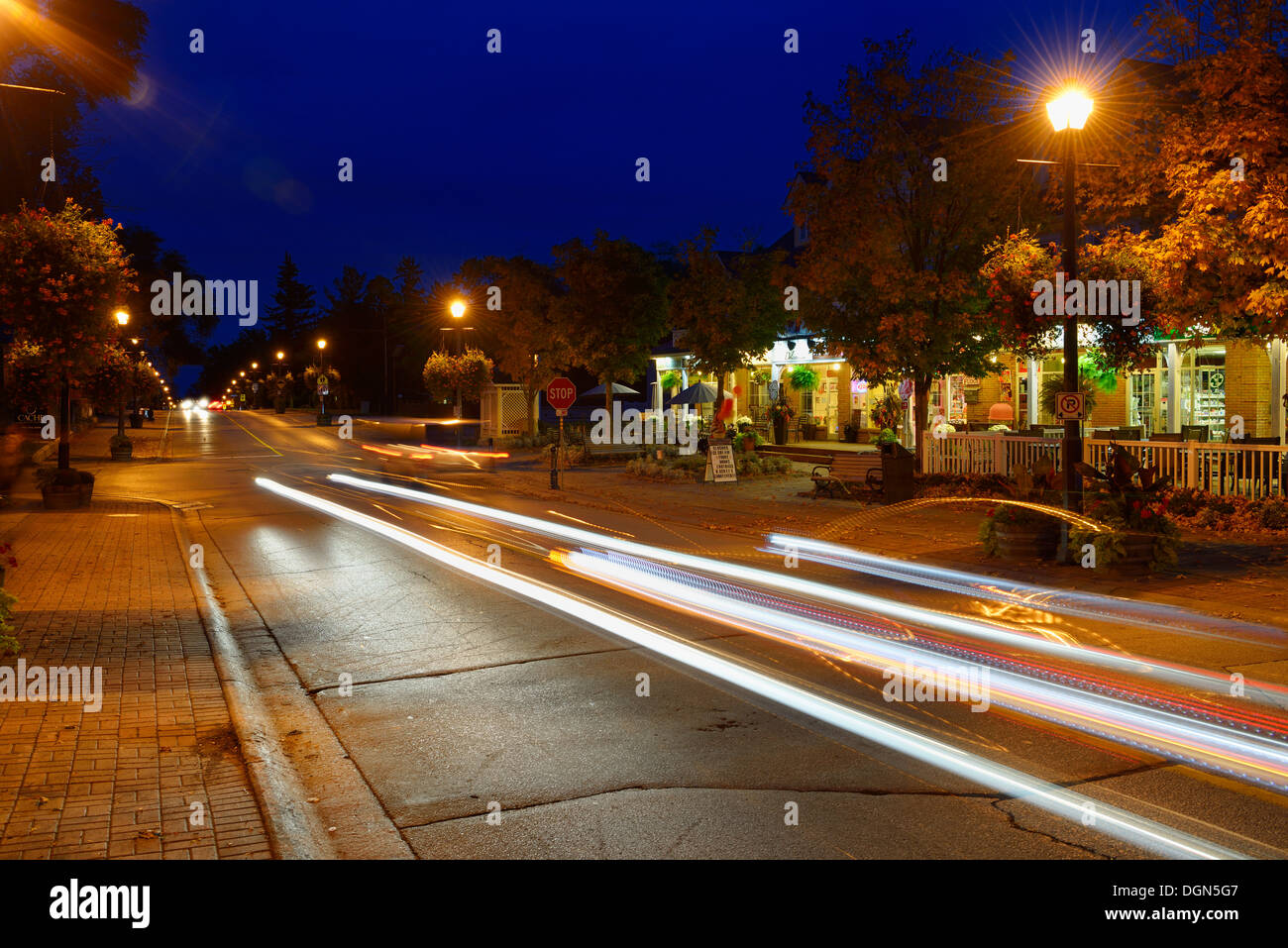 Des traînées de phares de voiture au crépuscule avec des magasins à Kleinburg (Ontario) Banque D'Images