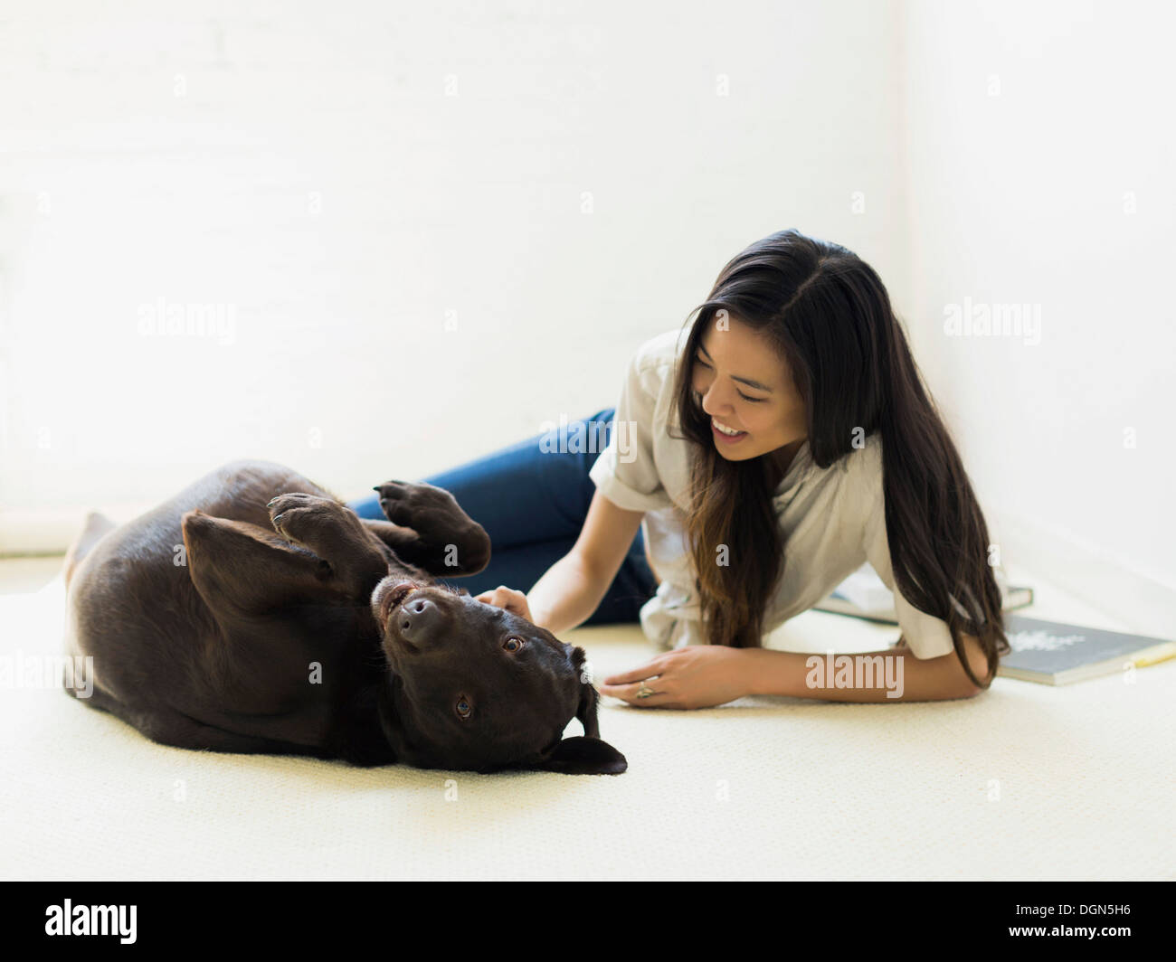 Woman with dog lying on floor Banque D'Images