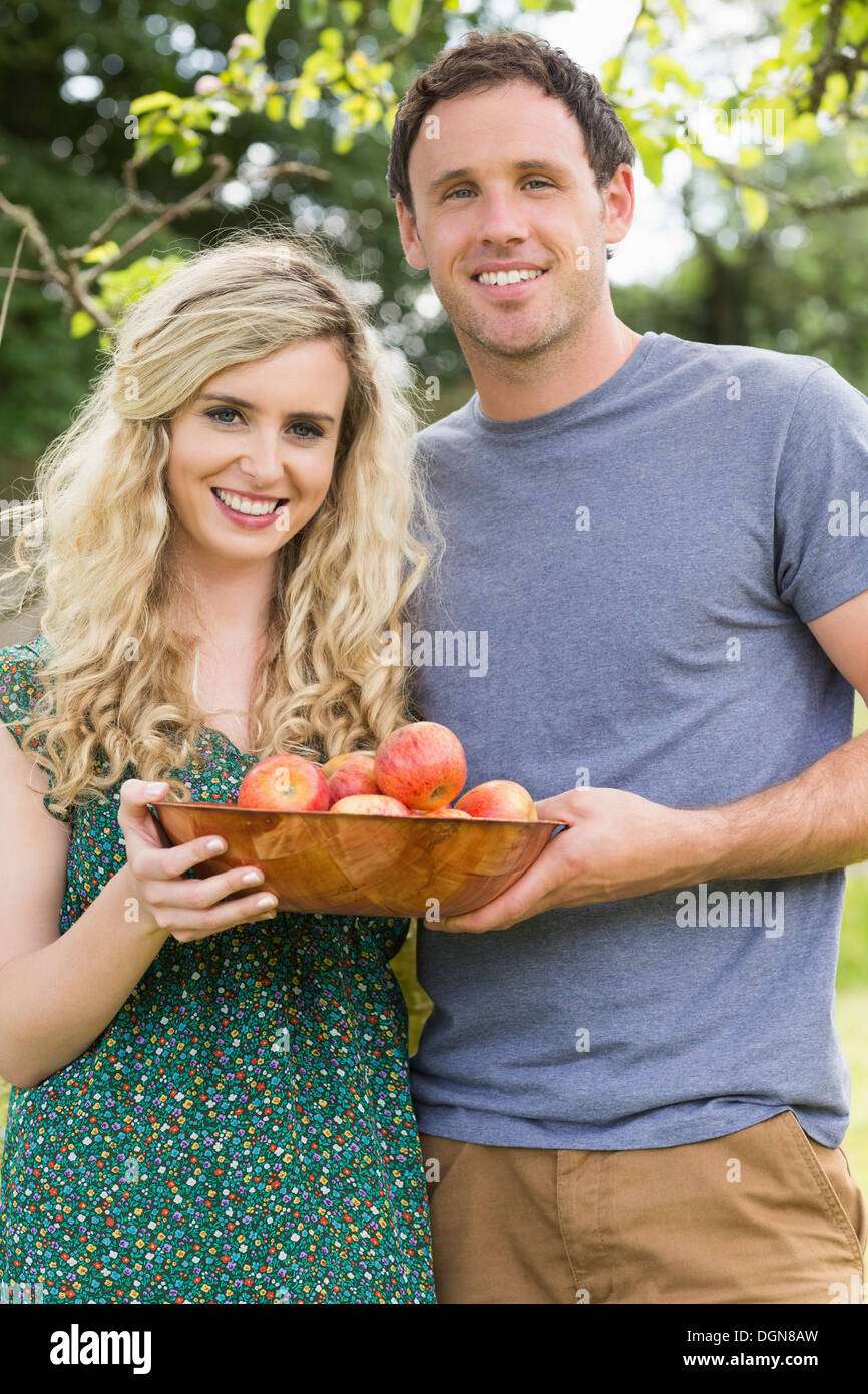 Young couple holding un bol avec des pommes Banque D'Images