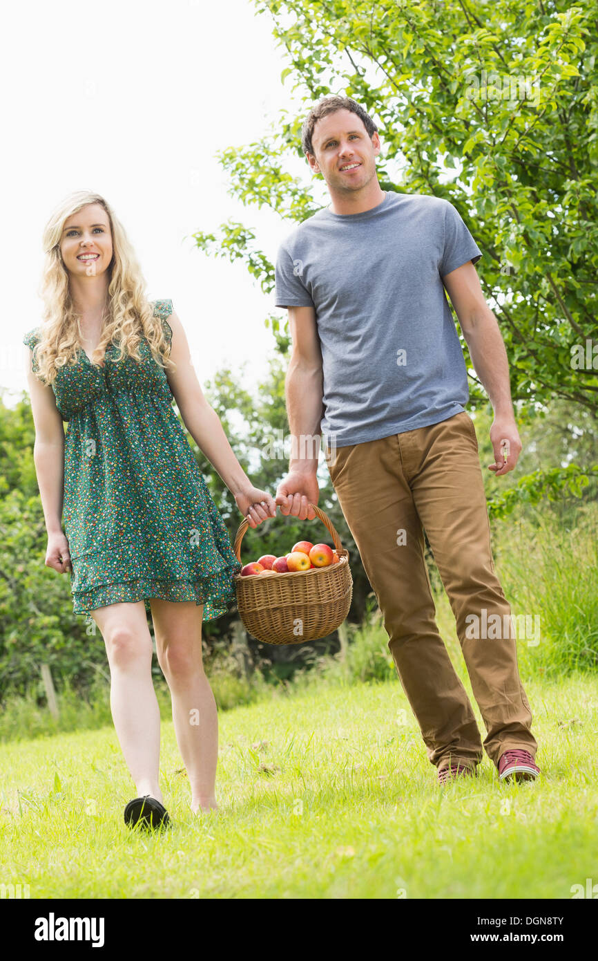 Sweet couple transportant un panier de pommes Banque D'Images