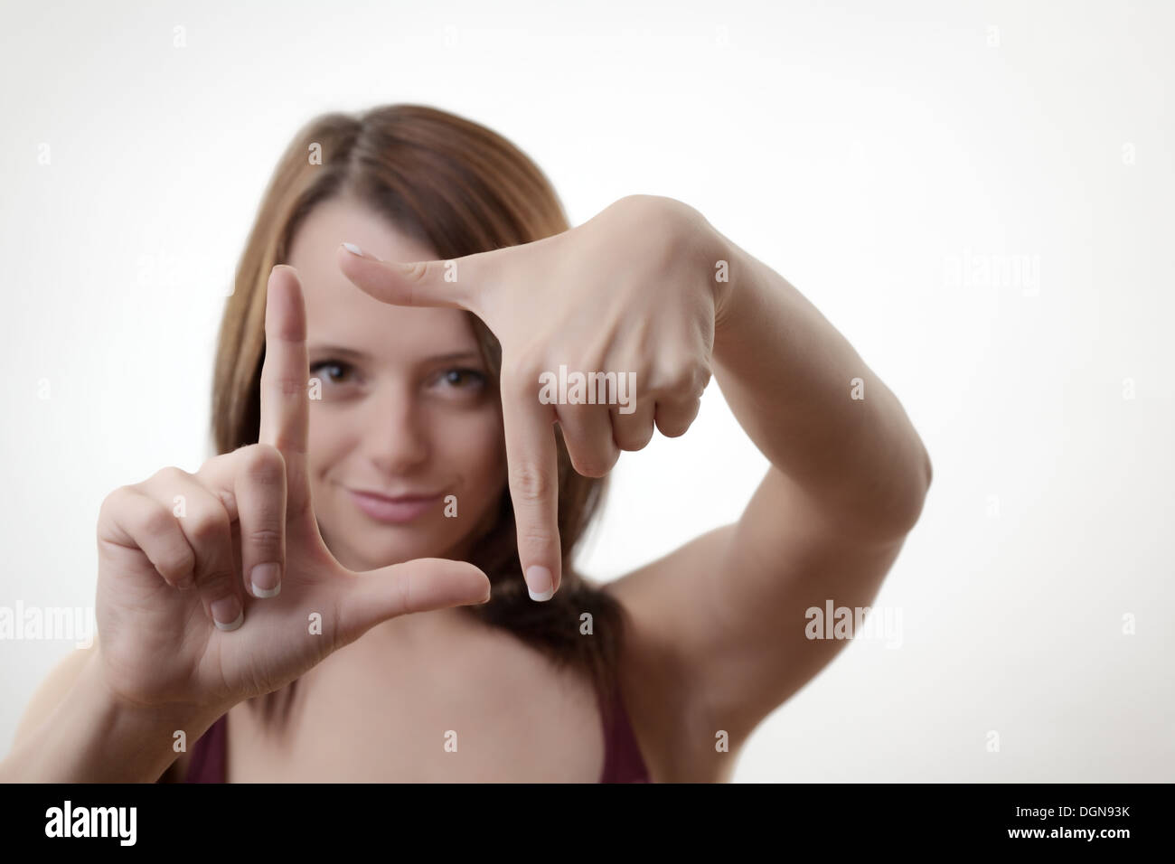 Belle jeune femme d'affaires faire un cadre avec ses mains Banque D'Images