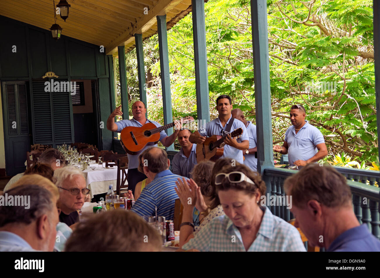 Groupe d'avoir le déjeuner à Manaca Iznaga comme seranaded ils sont par des musiciens locaux Banque D'Images