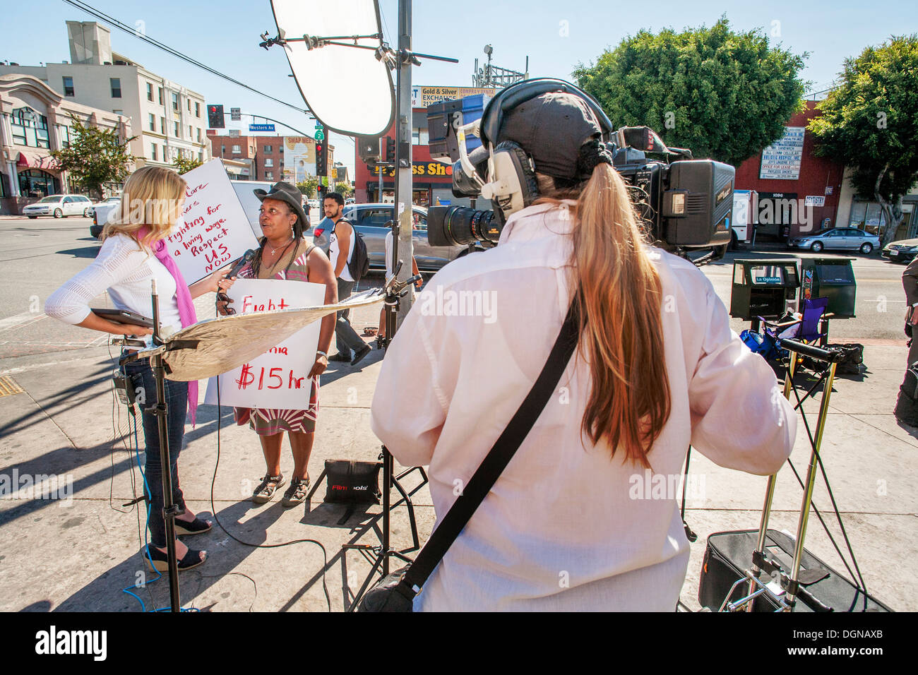 Un journaliste de télévision interviews un African American Woman participant à une manifestation de travailleurs de la restauration rapide Banque D'Images