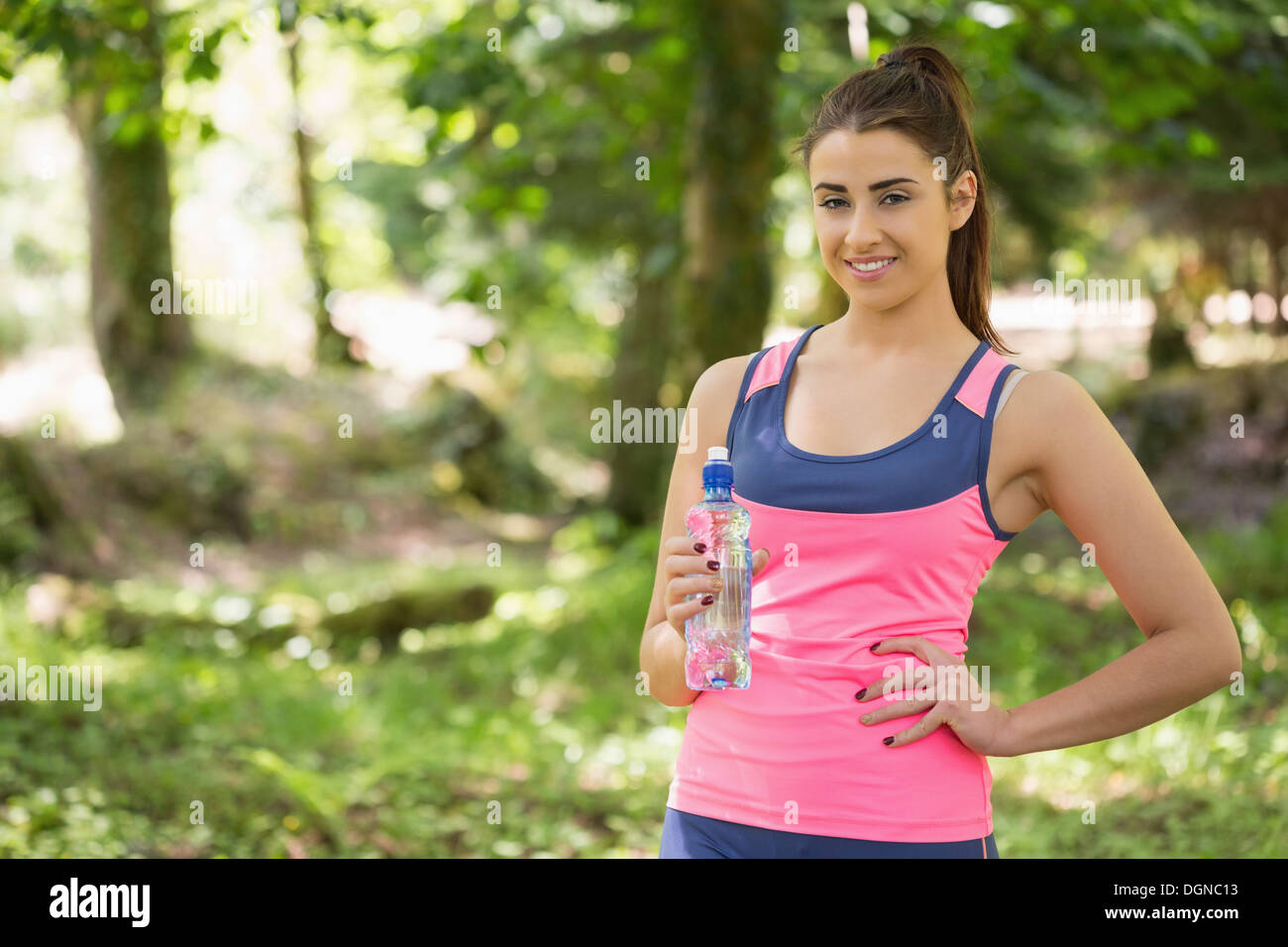 Monter cute woman wearing sportswear holding bottle Banque D'Images