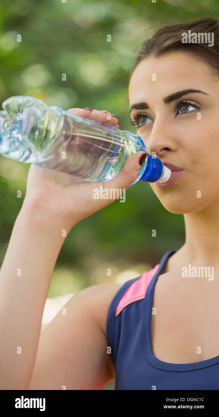 Monter cute woman wearing sportswear drinking from bottle Banque D'Images