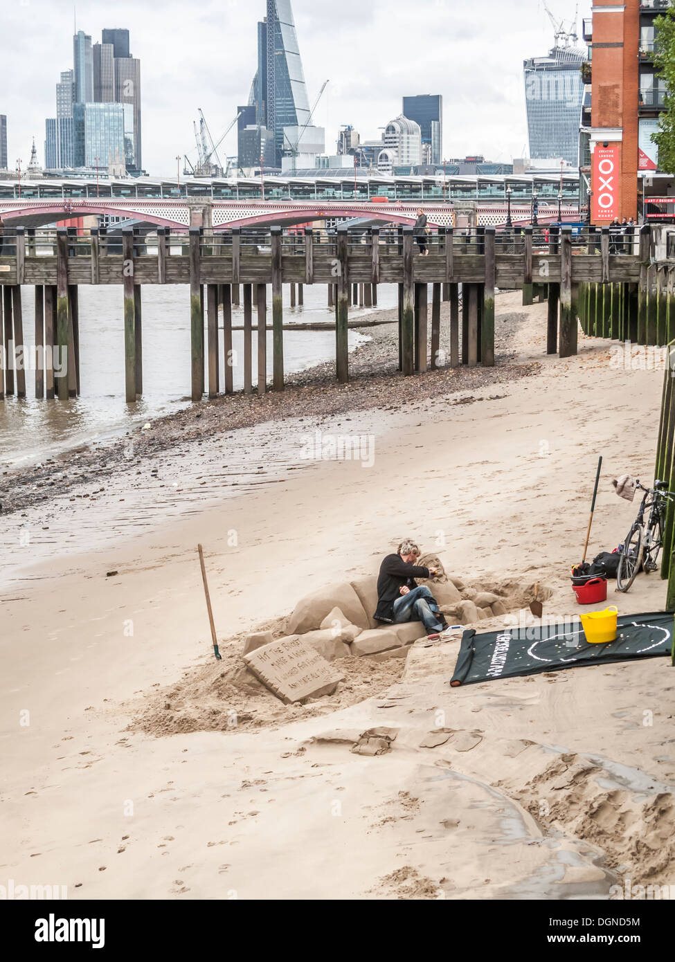 Sculptures de sable de sculpteur créer un homme couchée sur un canapé, sur la rive sud de la Tamise, Londres, Royaume-Uni pour des conseils Banque D'Images