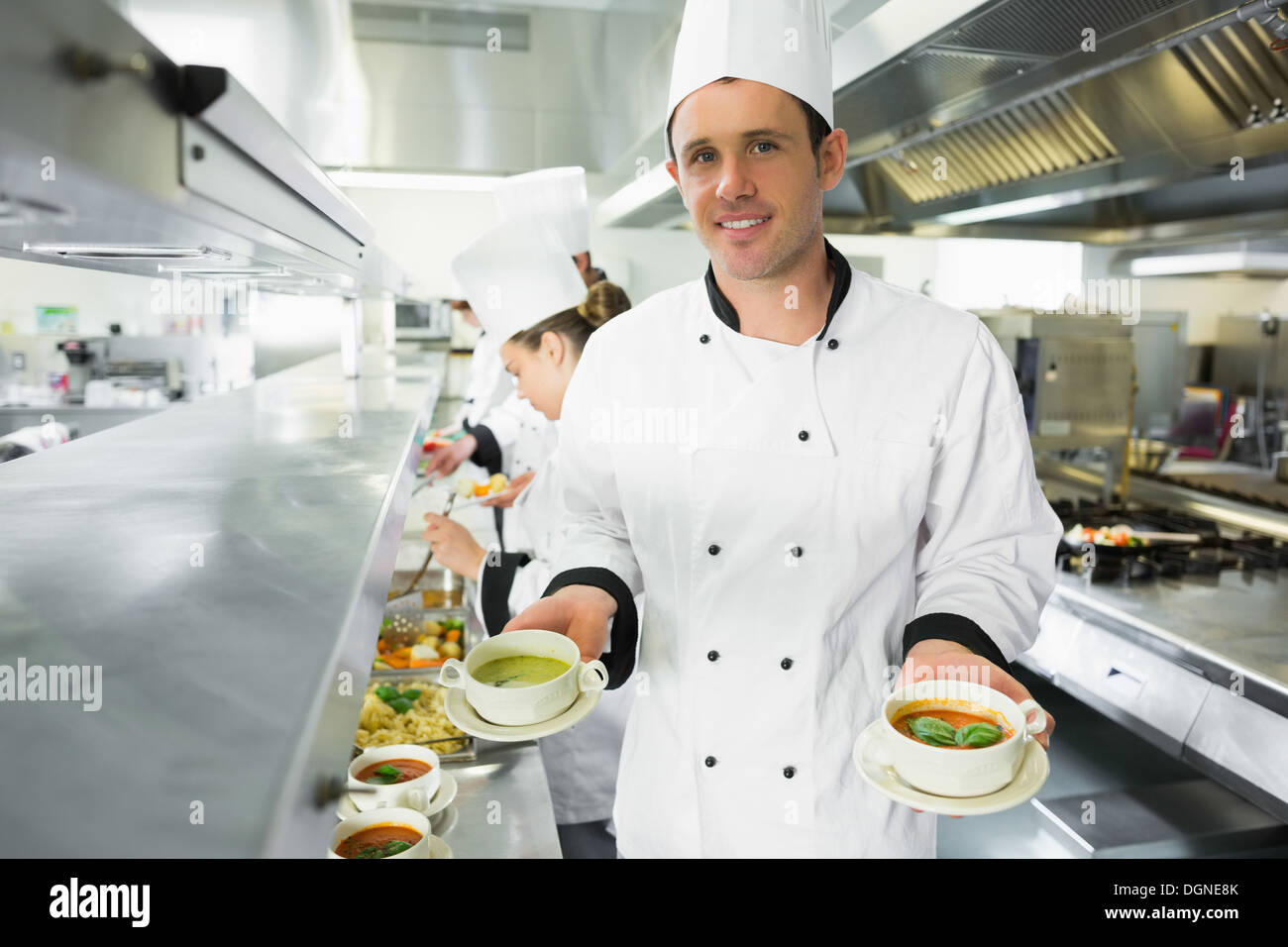 Happy chef présentant deux types de soupe Banque D'Images