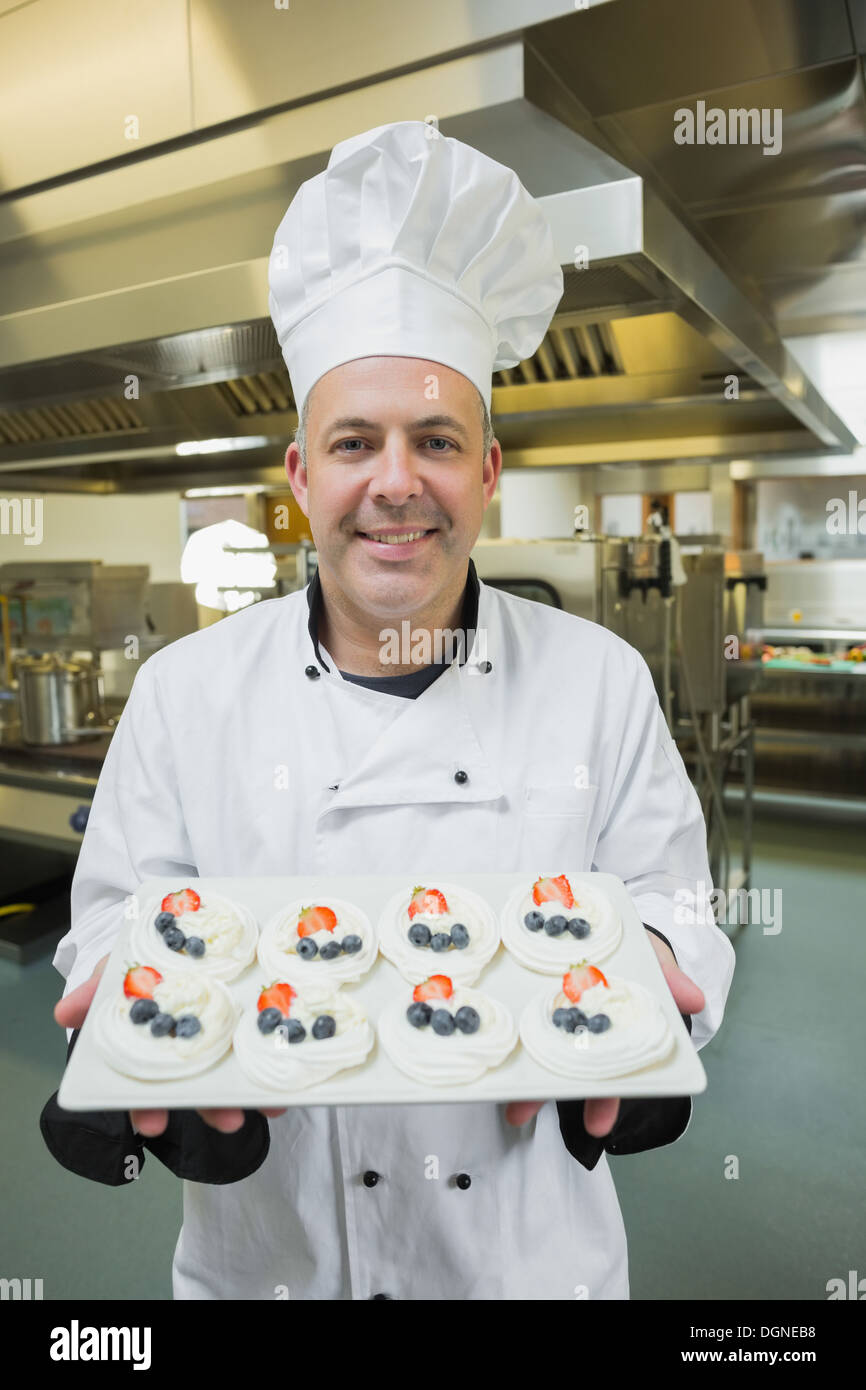 Mature chef presenting proudly plate de meringues Banque D'Images