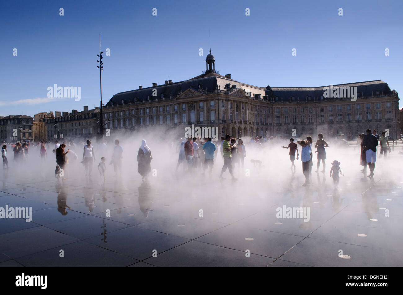 Les gens qui marchent dans la pulvérisation des mots plus grand miroir d'eau à la place de la Bourse, Bordeaux, France Banque D'Images