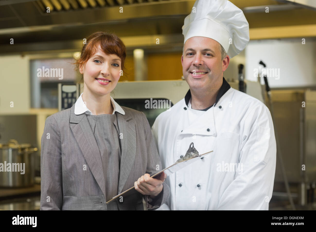 Mature chef cuisinier posant avec la femme manager Banque D'Images