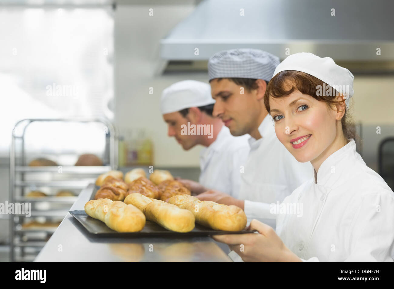 Happy female baker smiling at the camera Banque D'Images