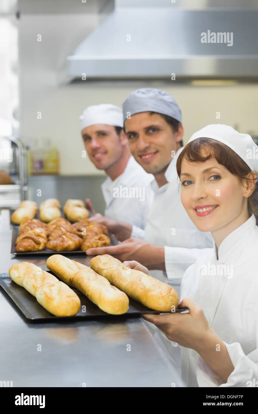 Trois jeunes boulangers holding plaques de cuisson Banque D'Images