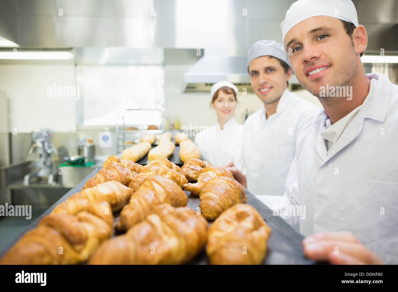 Trois jeunes boulangers posant dans une boulangerie Banque D'Images