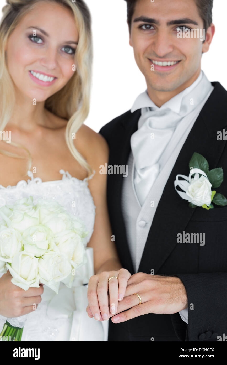 Deux jeunes mariés posing wearing wedding rings Banque D'Images