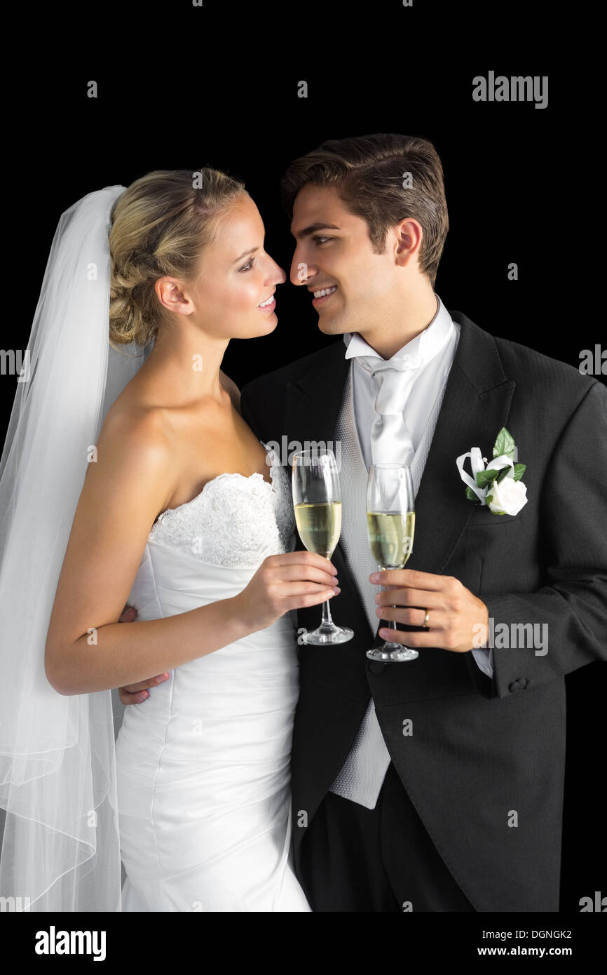 Superbe couple de jeunes mariés posing holding champagne glasses Banque D'Images