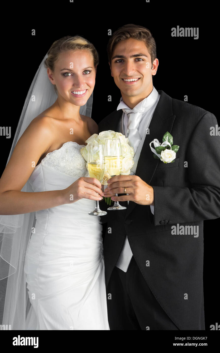 Couple marié contenu posing holding champagne glasses Banque D'Images