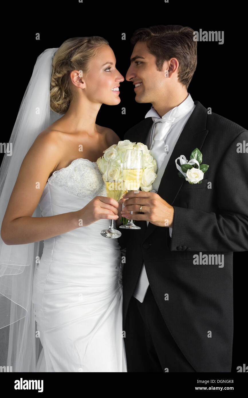 Joli couple posing holding champagne glasses Banque D'Images