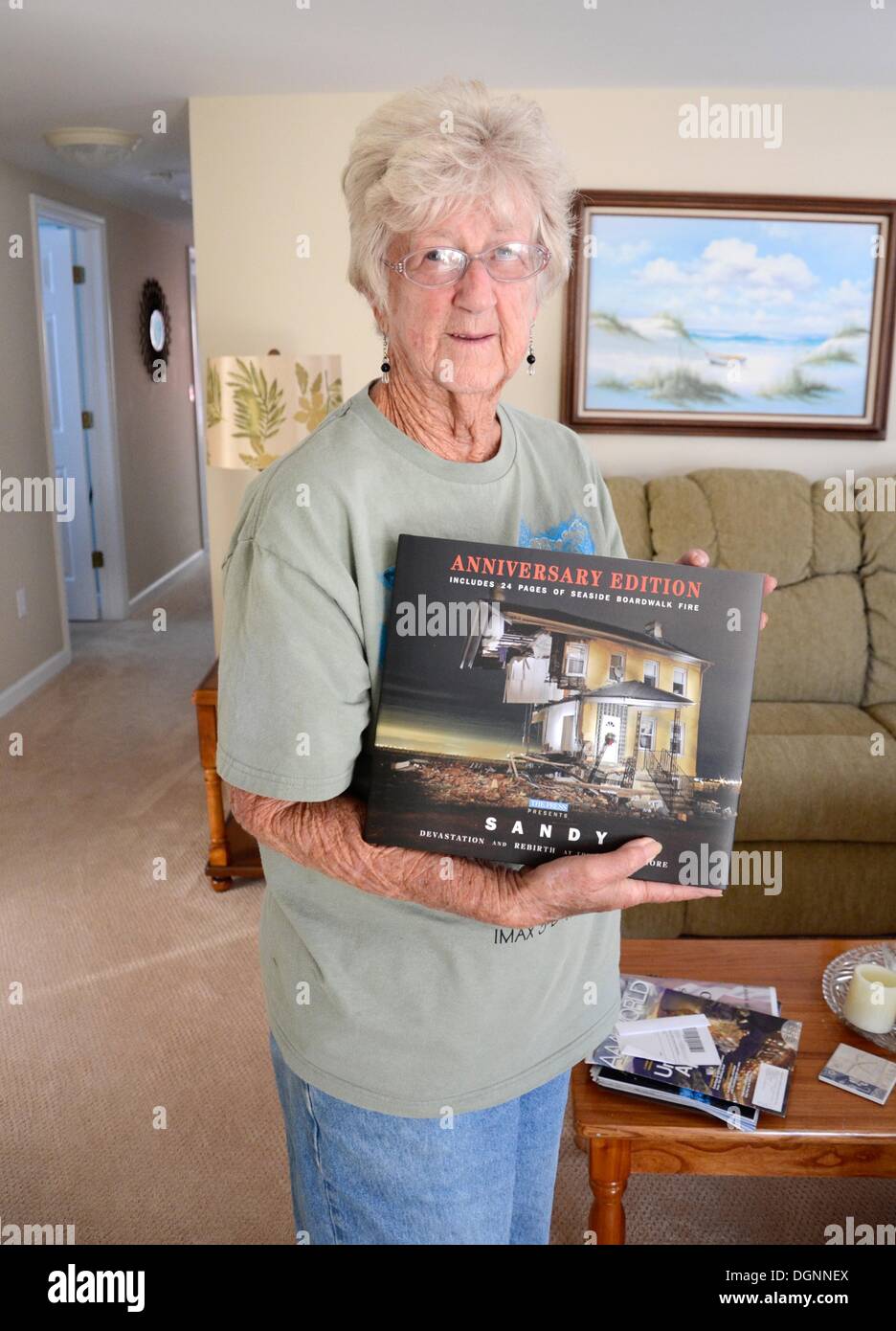 Seaside Heights, New Jersey, USA. 20 Oct, 2013. Birban Flo nous tend un livre sur la destruction de l'ouragan 'Sandy' dans sa maison reconstruite de Seaside Heights, New Jersey, USA, 20 octobre 2013. Il y a un an, l'ouragan 'Sandy' à travers les Caraïbes et le long de la côte est des Etats-Unis. Plus de 140 personnes ont été tuées dans la tempête qui a causé des dommages coûtant des milliards. Beaucoup a été reconstruit, mais l'ouragan a laissé sa marque dans le peuple. Photo : EMOKE BEBIAK/dpa/Alamy Live News Banque D'Images