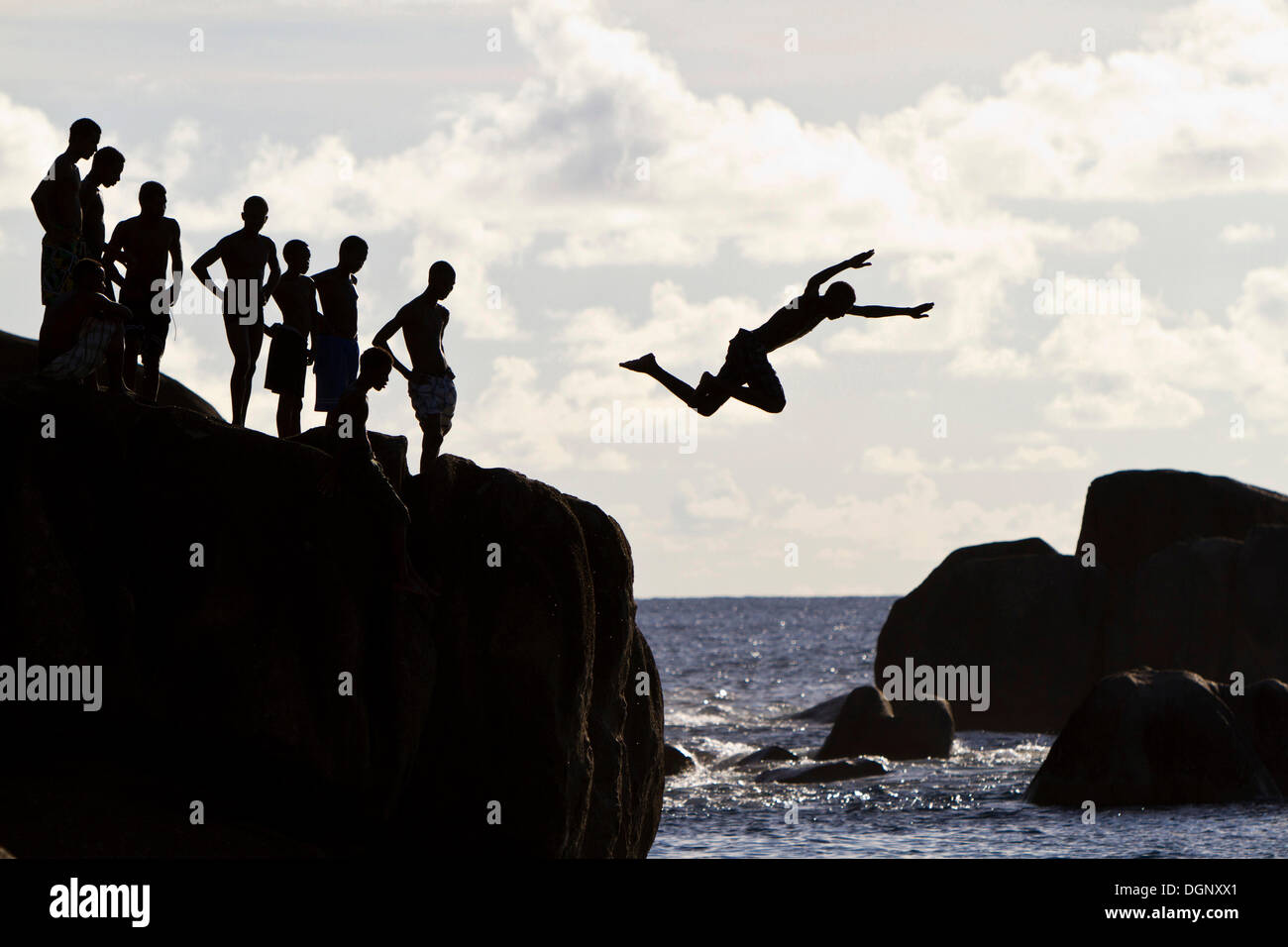 Les adolescents créole sautant de rochers, silhouettes, Mahé, Seychelles, Afrique, Océan Indien Banque D'Images