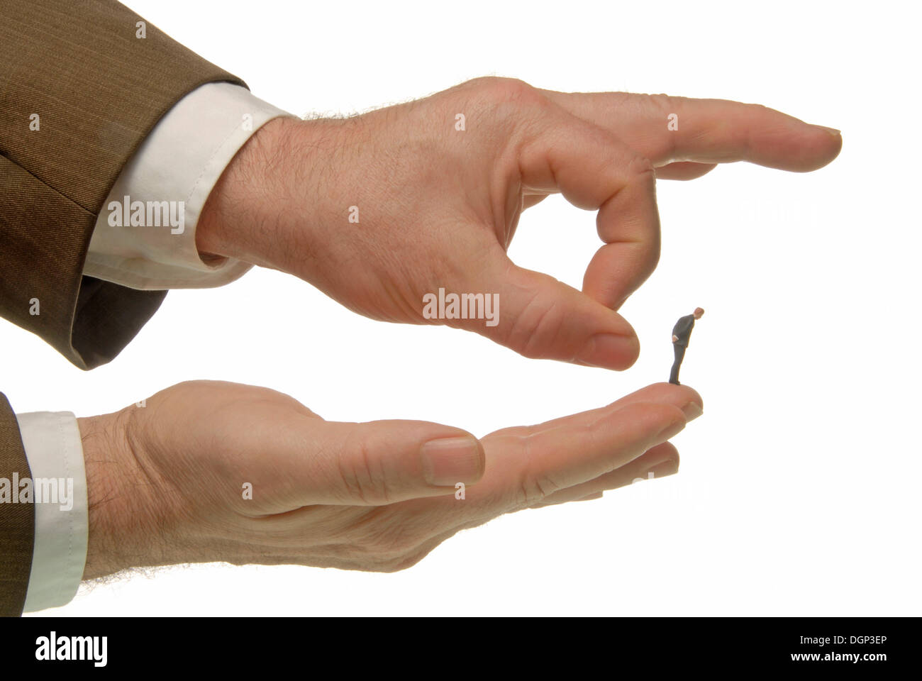 La main de l'homme un homme d'une pichenette miniature figure de son doigt, l'image symbolique de licenciement Banque D'Images