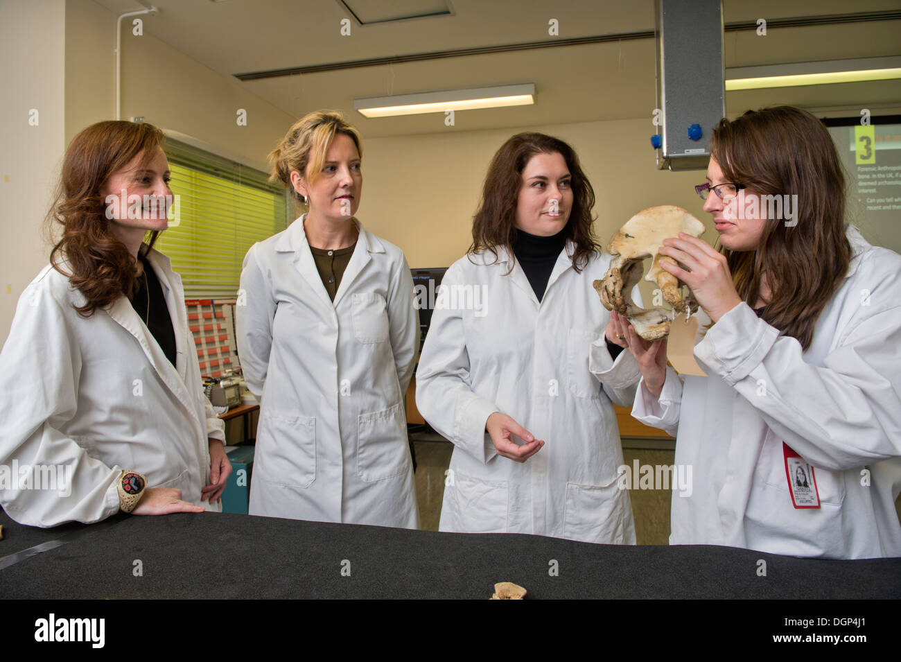 Les élèves acquièrent des connaissances sur l'identification de l'os avec l'anthropologue judiciaire Dr Anna Williams (centre droit) à l'Institut médico-légal Banque D'Images