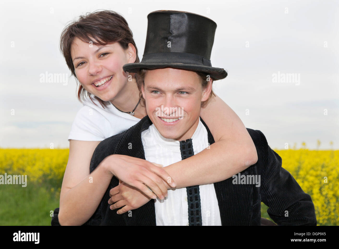Jeune femme avec top hat embrassant son petit ami qui la transporte sur son dos Banque D'Images