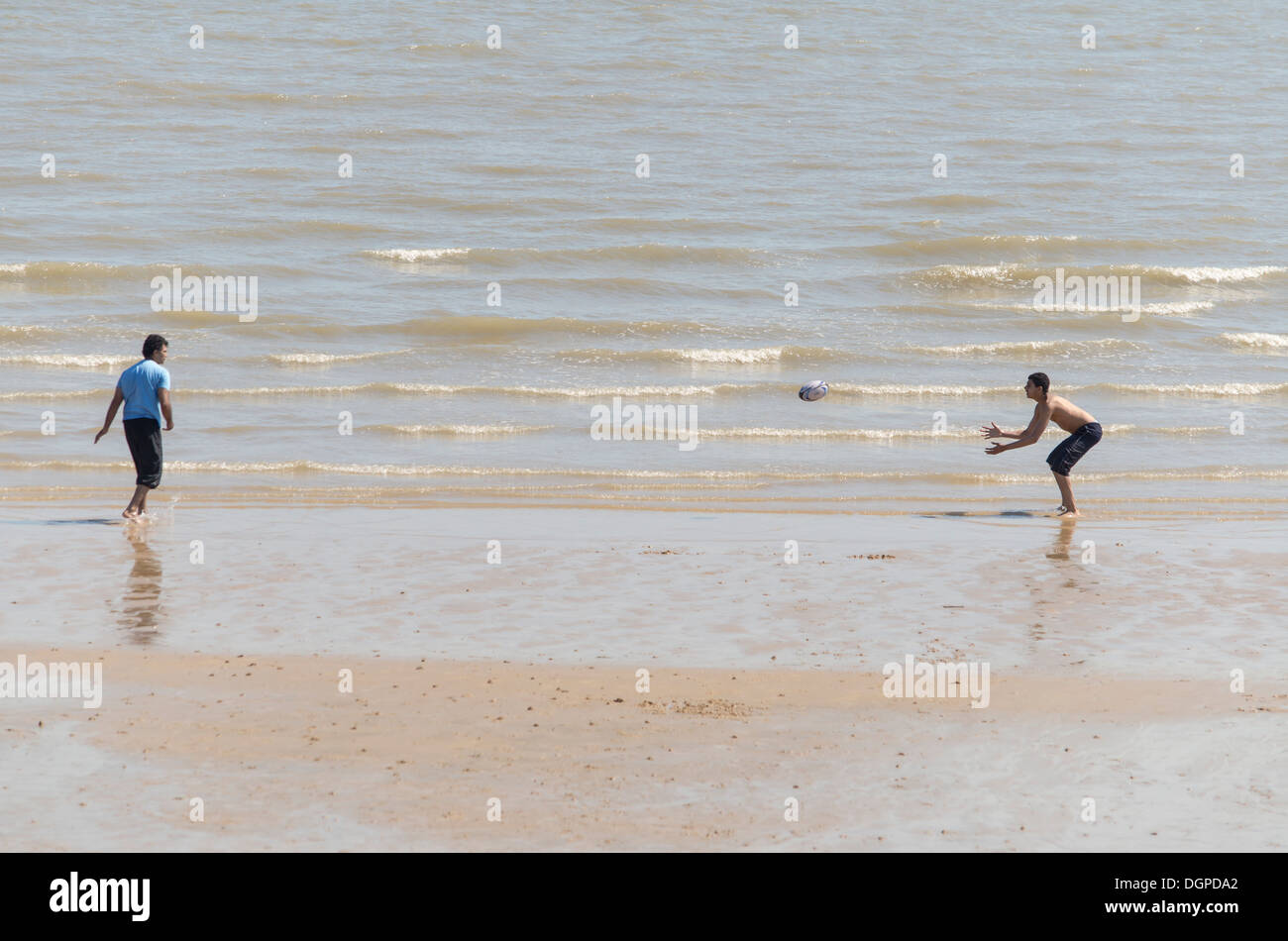 Jouer au rugby sur la plage Banque D'Images