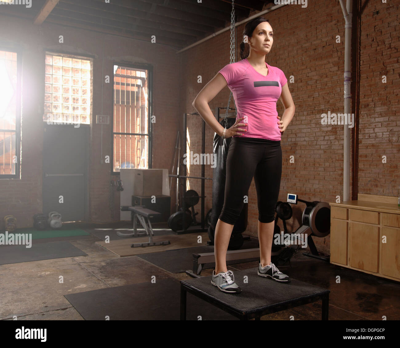 Young woman standing on table in gym Banque D'Images