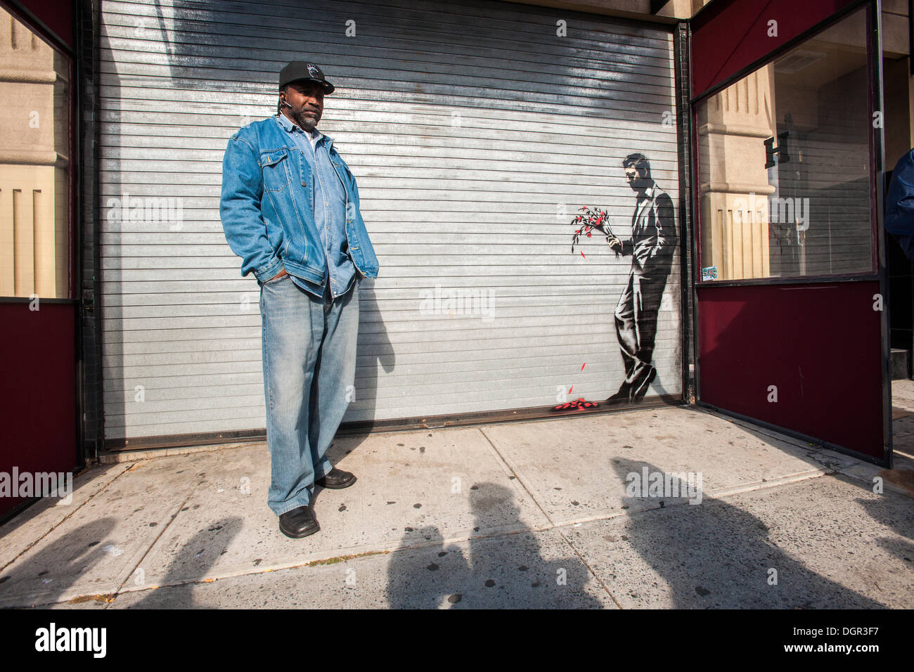 New York, NY, USA . 24 Oct, 2013. Les amateurs de street art affluent à Larry Flynt's Hustler Club dans le quartier Hell's Kitchen de New York le jeudi 24 octobre, 2013 pour voir 'attendre en vain' la vingt-quatrième tranche de graffiti de Banksy, l'art d'art au pochoir est sur le roll-up gate à l'entrée du club de gentlemen, qui a posté des gardes de sécurité à l'extérieur pour protéger leur nouveau chef d'œuvre. L'insaisissable artiste de rue, c'est la création d'œuvres autour de la ville chaque jour pendant le mois d'octobre intitulé "Mieux dehors que dans'. (© Richard B. Levine) Crédit : Richard Levine/Alamy Live N Banque D'Images