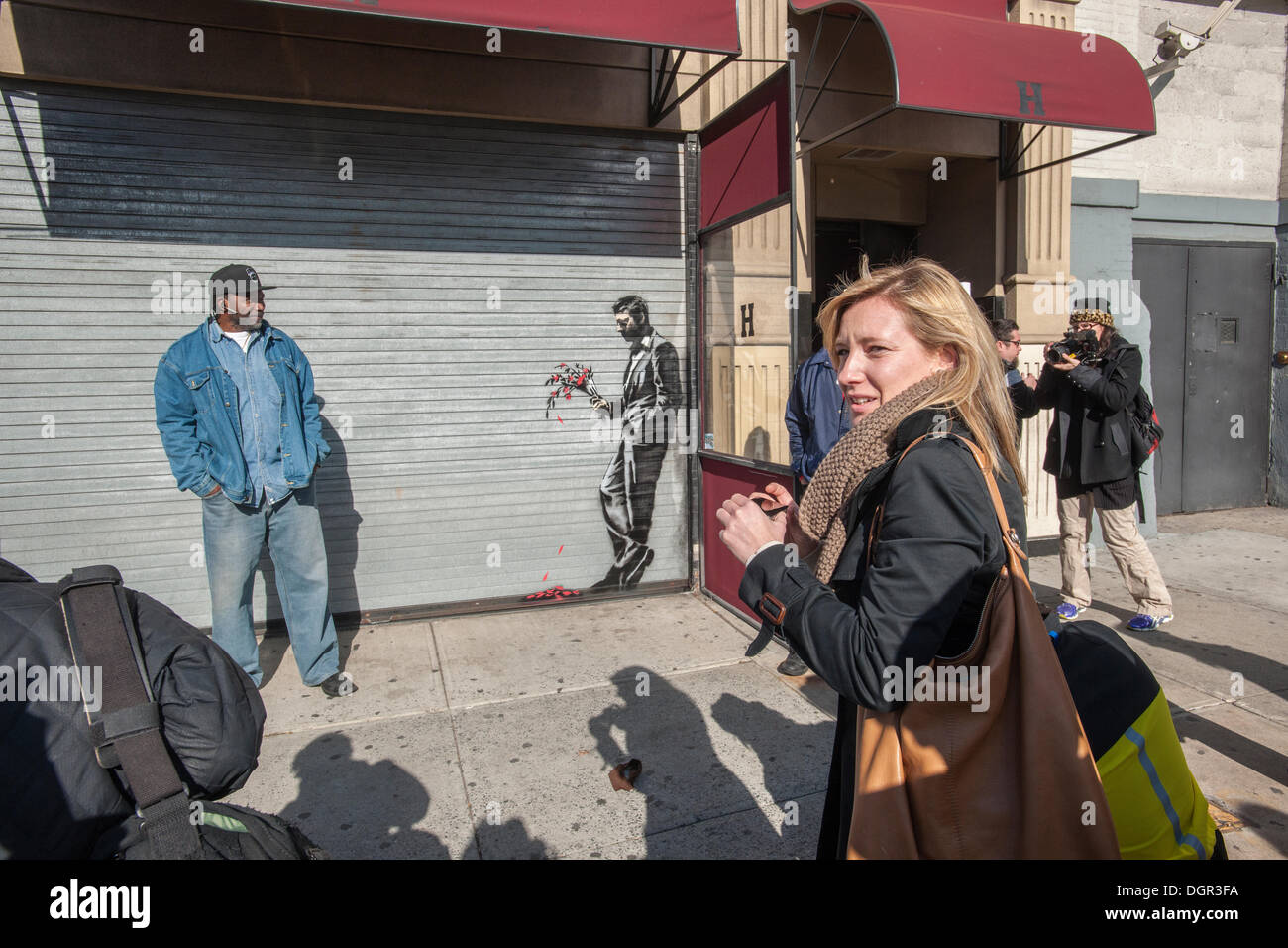 New York, NY, USA . 24 Oct, 2013. Les amateurs de street art affluent à Larry Flynt's Hustler Club dans le quartier Hell's Kitchen de New York le jeudi 24 octobre, 2013 pour voir 'attendre en vain' la vingt-quatrième tranche de graffiti de Banksy, l'art d'art au pochoir est sur le roll-up gate à l'entrée du club de gentlemen, qui a posté des gardes de sécurité à l'extérieur pour protéger leur nouveau chef d'œuvre. L'insaisissable artiste de rue, c'est la création d'œuvres autour de la ville chaque jour pendant le mois d'octobre intitulé "Mieux dehors que dans'. (© Richard B. Levine) Crédit : Richard Levine/Alamy Live N Banque D'Images
