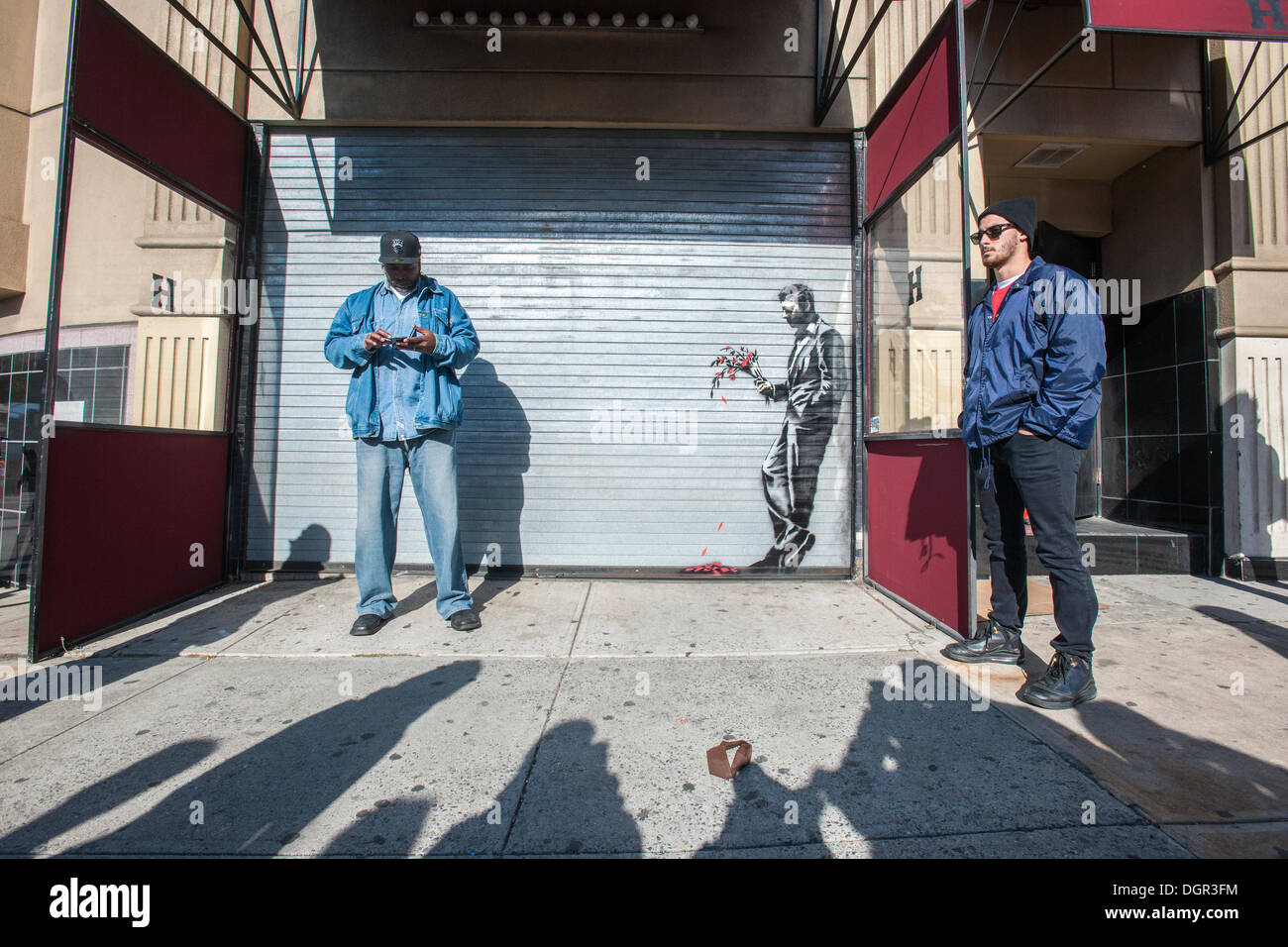New York, NY, USA . 24 Oct, 2013. Les amateurs de street art affluent à Larry Flynt's Hustler Club dans le quartier Hell's Kitchen de New York le jeudi 24 octobre, 2013 pour voir 'attendre en vain' la vingt-quatrième tranche de graffiti de Banksy, l'art d'art au pochoir est sur le roll-up gate à l'entrée du club de gentlemen, qui a posté des gardes de sécurité à l'extérieur pour protéger leur nouveau chef d'œuvre. L'insaisissable artiste de rue, c'est la création d'œuvres autour de la ville chaque jour pendant le mois d'octobre intitulé "Mieux dehors que dans'. (© Richard B. Levine) Crédit : Richard Levine/Alamy Live N Banque D'Images