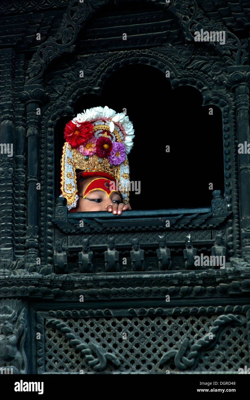 Dieu vivant de Katmandou, Bhairava, lorgnant par la fenêtre en bois joliment sculpté. Banque D'Images