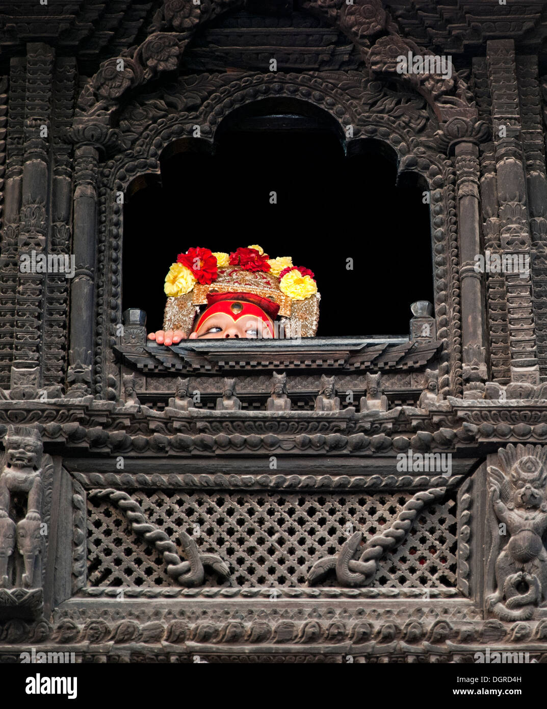 Dieu vivant de Katmandou peeping à partir d'une fenêtre de bois sculpté. Banque D'Images