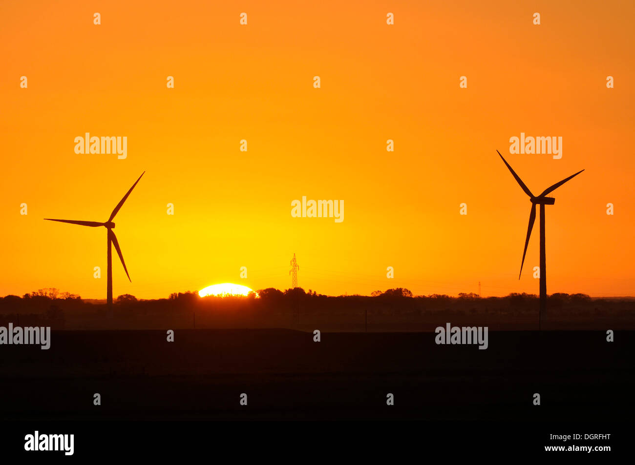 L'aube nucléaire, éolienne et de la ligne de transport à l'avant d'un lever de soleil, eiderstedt, Schleswig-Holstein Banque D'Images