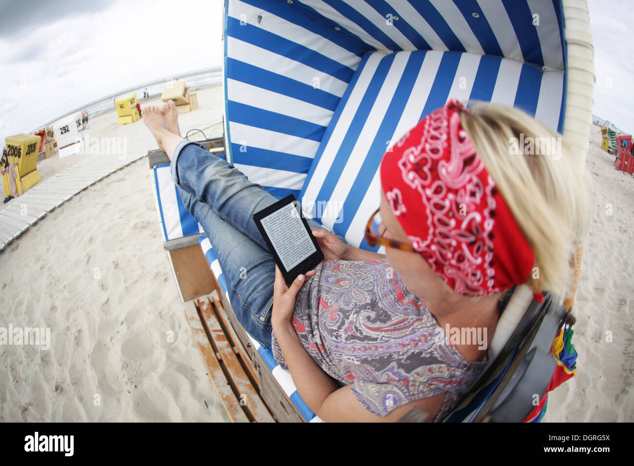 Allemagne, Basse-Saxe, Frise Orientale, Berlin, young woman e-book à la plage Banque D'Images