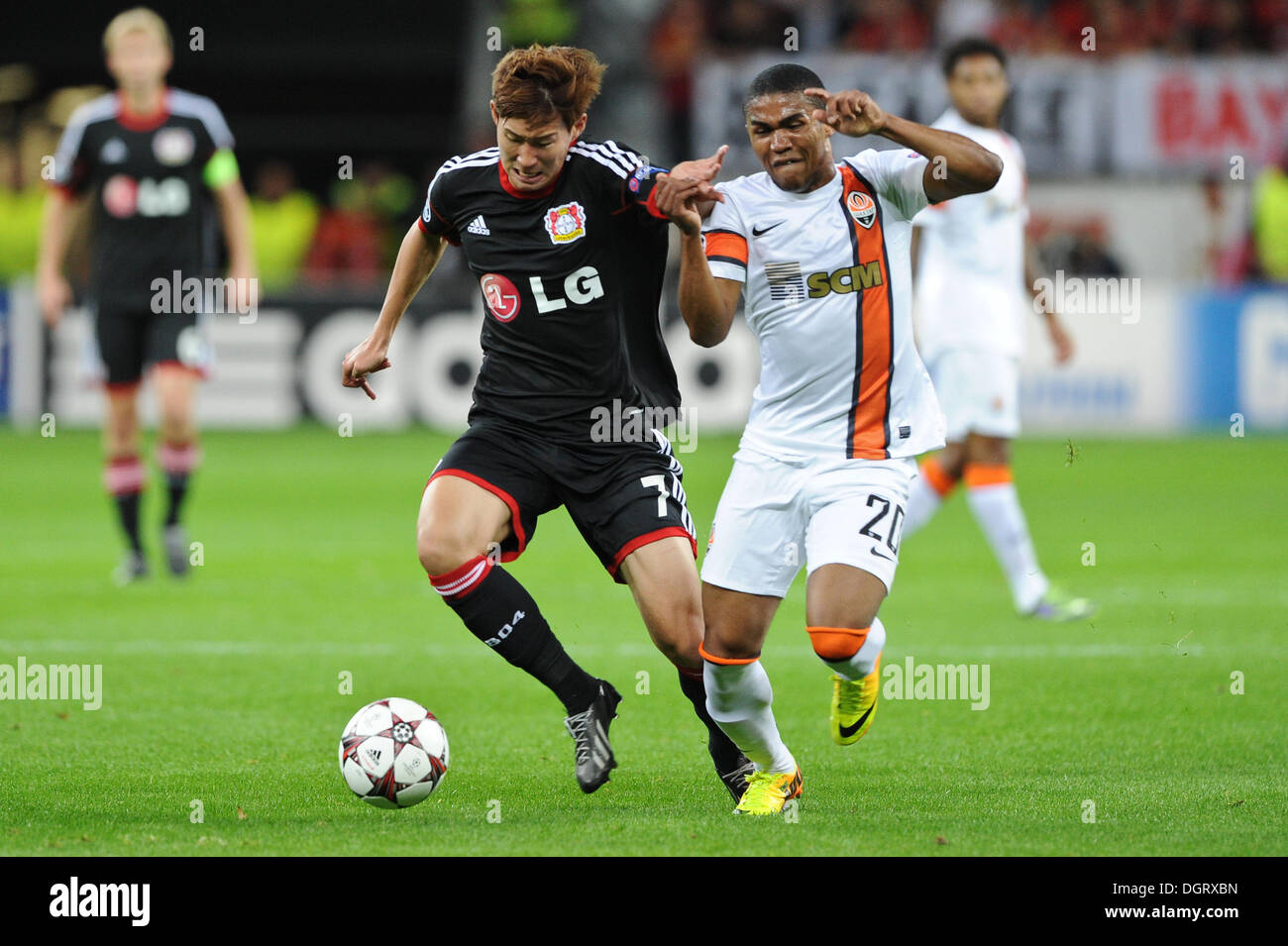 Leverkusen, Allemagne. 23 Oct, 2013. Le Fils de Leverkusen Heung-Min (L) convoite la la balle avec le Shakhtar Donetsk Douglas Costa lors de la Ligue des Champions groupe A match entre Bayer 04 Leverkusen et le FC Shakhtar Donetsk à la BayArena à Leverkusen, Allemagne, 23 octobre 2013. Photo : Frederic Scheidemann/dpa/Alamy Live News Banque D'Images