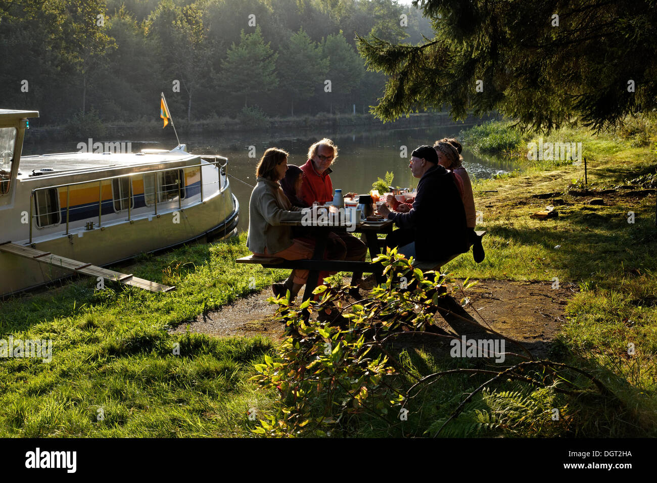 Les vacanciers de prendre le petit déjeuner sur une table de pique-nique, un matin de l'humeur, péniche sur le canal des Vosges, anciennement Canal de l'Est Banque D'Images