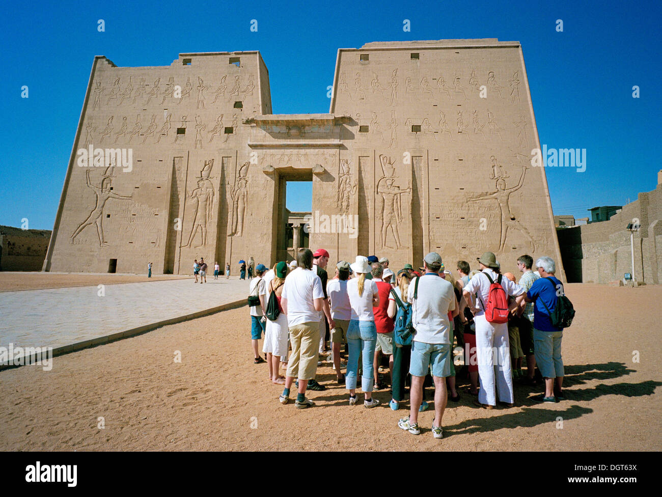 Un groupe de touristes avec leur guide à l'entrée pylônes du temple d'Horus à Edfou, sur les rives du Nil, l'Egypte Banque D'Images