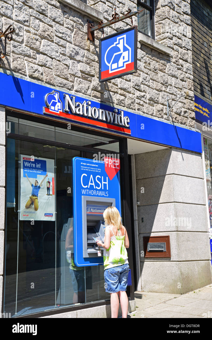 Femme utilisant une machine à billets à Nationwide Bank, Fore Street, Redruth, Cornwall, Angleterre, Royaume-Uni Banque D'Images