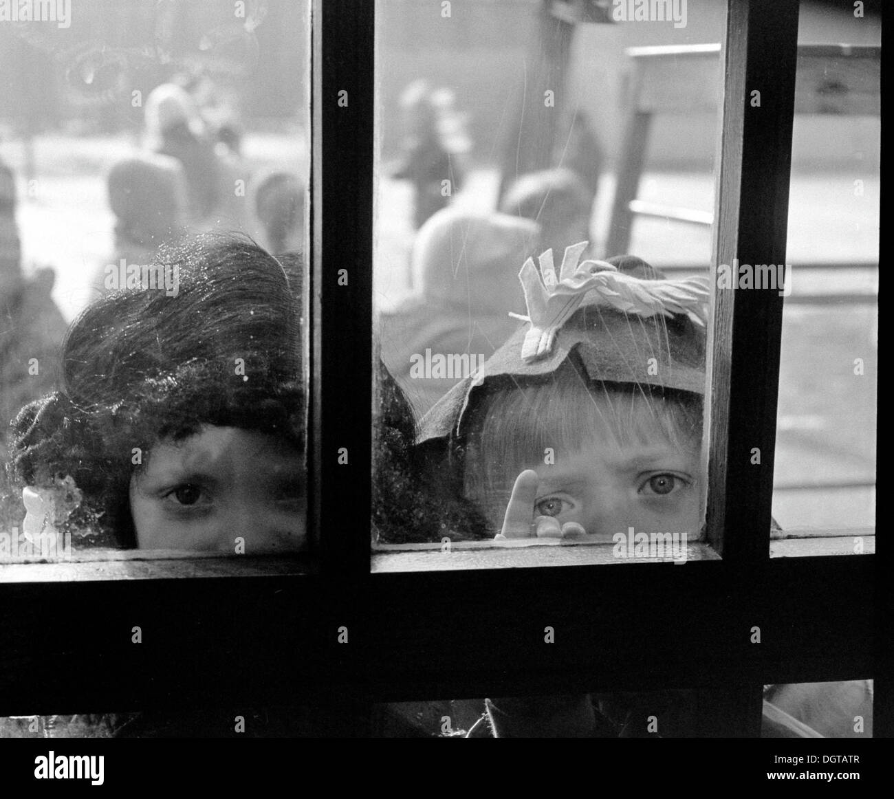 Les enfants déguisés en regardant par la porte de verre, Leipzig, Allemagne de l'Est, à propos de 1976 Banque D'Images