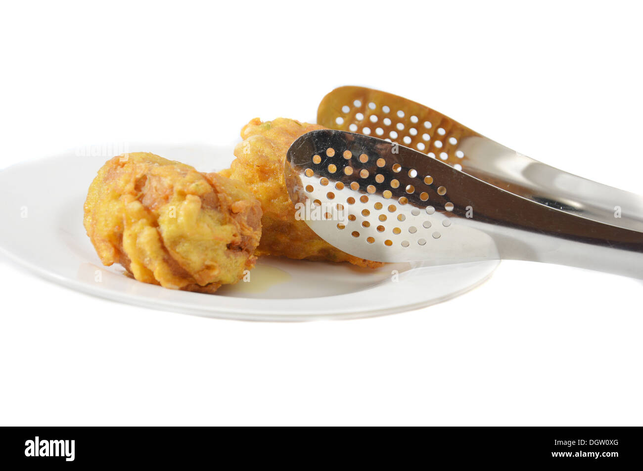 Tofu frit avec des pinces en acier isolé sur fond blanc Banque D'Images