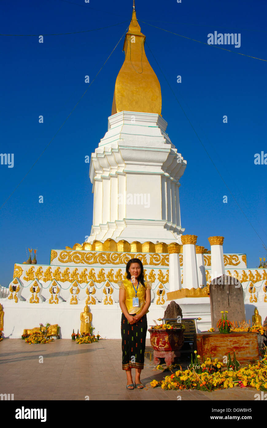 Le laotien femme debout en face d'un grand stupa en blanc et or, jupe, nas, Pha Si Kotabong, Tha Khek Banque D'Images
