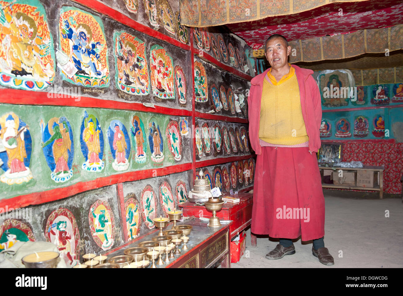 Le bouddhisme tibétain, moine dans une chambre avec des reliefs peints de couleurs vives, Gossul rock Monastère Gompa au-dessus du lac Manasarovar Banque D'Images